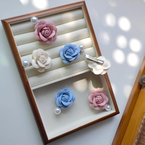 Détail de pinces à cheveux camélia avec pétales en tissu doux et perles blanches
