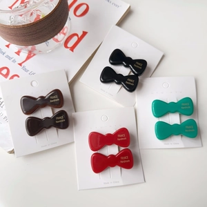 Détail de pinces à cheveux nceud en acétate en noir marron rouge et vert sur cartes