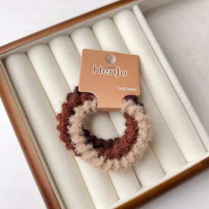 Dettaglio degli elastici per capelli in peluche marrone e beige con trama di pelliccia
