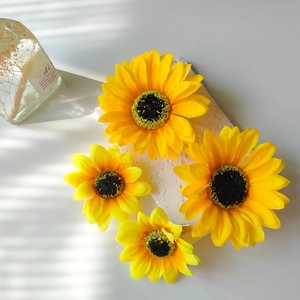 Close-up of artificial sunflower hair clips with realistic fabric petals and metal fasteners