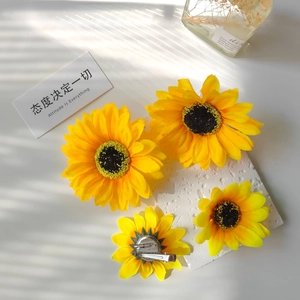 Detailed back view of sunflower hair clips showing metal alligator clips and brooch pins