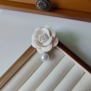 Détail de la pince à cheveux camélia avec pétales de velours blanc et perle élégante