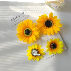 Close-up of artificial sunflower hair clip with silver metal brooch pin and duckbill clip