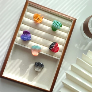 Close-up of colorful mini heart hair claws with white polka dots on a velvet tray