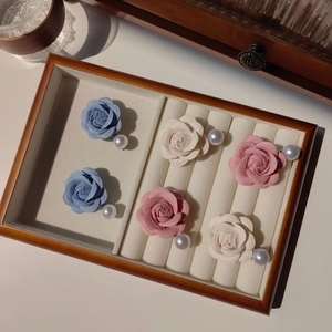 Gros plan de barrettes camélia 3D avec perles élégantes en bleu, blanc et rose
