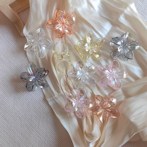 Detail of translucent frangipani hair claw clips with iridescent aurora coating finish
