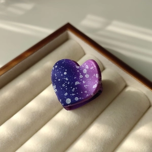 Detailed view of heart-shaped hair claw clip with purple gradient and white polka dots