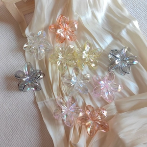 Collection of colorful gradient translucent flower hair claw clips on white satin fabric