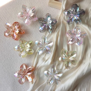 Aurora laser flower hair claw clips in assorted gradient colors on silk fabric