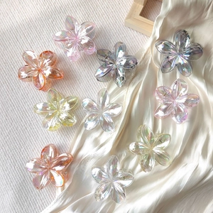 Detailed view of ten colorful gradient plumeria hair claws in various iridescent finishes