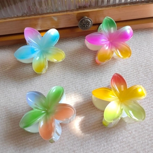 Set of four gradient plumeria hair claws in pink, blue, yellow on white knit texture