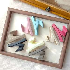 Detailed view of seven colorful matte resin claw clips in a minimalist shark fin shape