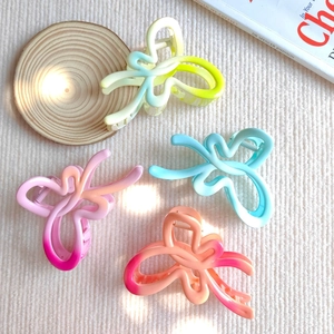 Set di quattro mollette per capelli a farfalla traforate con colori sfumati e finitura opaca