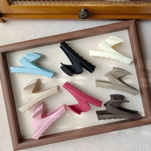 Detailed view of matte Z-shaped claw clips in 8 colors displayed on a beige wooden tray