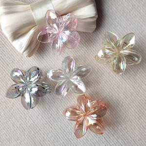 Detailed view of 5-piece gradient frangipani flower hair claws with aurora rainbow coating