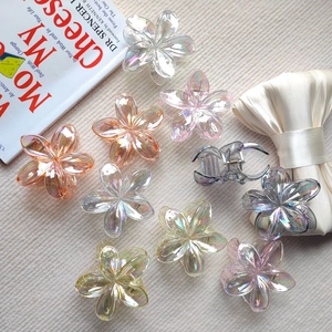 Detailed macro view of colorful iridescent flower hair clips on a textured background
