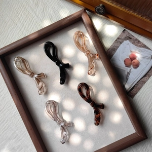 Barrettes banane verticales en forme de nœud en cinq couleurs sur plateau en bois