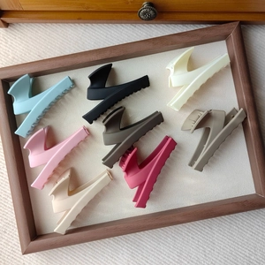 Set of eight matte finish claw clips in various colors displayed in a wooden frame