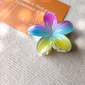 Macro detail of gradient purple and blue flower hair claw clip with frosted resin texture