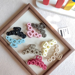 Detail view of colorful matte hollow circle hair claws on rustic wood frame