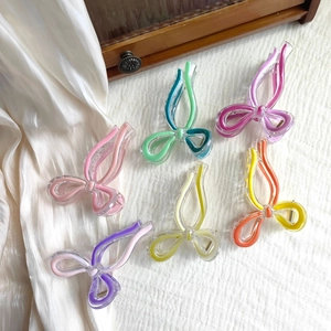 Close-up of colorful butterfly hair claws in various vibrant shades on white fabric