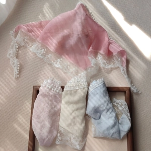 Detailed macro view of lace-edged triangle headscarves in pink, white and blue colors