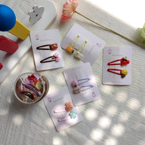 Close-up of cute cartoon hair clips set with rabbit, carrot and fruit designs for girls