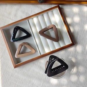Detail of matte triangular hair claws in black and brown finishes on a jewelry tray