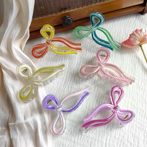 Detail of six colorful acrylic butterfly hair claws on a vintage wooden box background