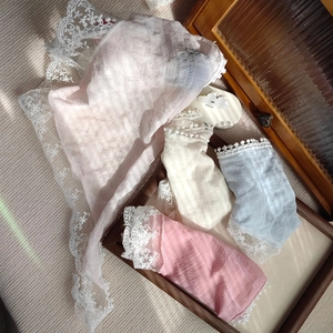 Detailed close-up of lace-trimmed textured socks in soft pastel colors and vintage style