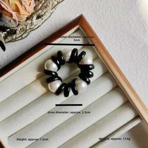 Detail view of pearl spiral hair tie with dimensions 5cm outer and 2.5cm inner diameter