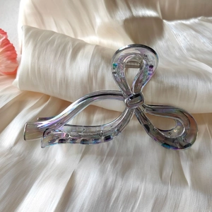Close-up of holographic large shark hair clip with iridescent butterfly twist design