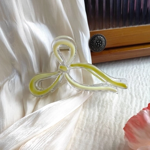 Detail of a large butterfly hair claw clip with lime green resin on white silk