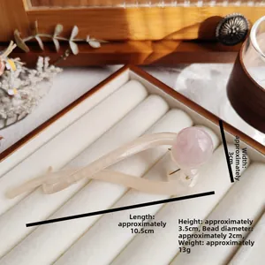 Detail view of a beige hair claw clip with pink pearl decor including size measurements