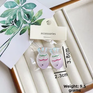Detailed view of two gradient fish hair clips measuring 3.8cm in a soft jewelry box