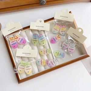 Colorful gradient fish hair clips in resin presented in a white jewelry display tray