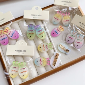Detailed view of colorful gradient fish hair clips with resin finish and metal fasteners
