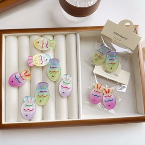 Close-up of colorful gradient fish-shaped DIY acrylic hair accessories on white tray