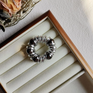 Close-up of pearl telephone wire hair tie with silver spiral cord in wooden jewelry box
