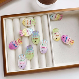 Macro view of colorful gradient fish-shaped resin pendants in various macaron shades