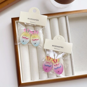Detail of colorful gradient fish resin charms on accessories card in jewelry tray