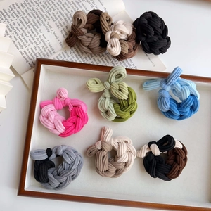 Detail of multi-color woven elastic hair ties with textured fabric and decorative knots