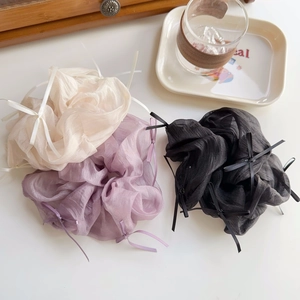Detailaufnahme von Organza-Haargummis mit eleganten Schleifen in Weiß, Lila und Schwarz