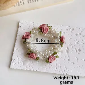 Detail von handgemachtem Perlenhaargummi mit rosa Seidenrosen und Maßen von 8,8 cm