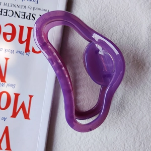 Detailed view of a purple translucent cloud hair claw clip on a white textured background