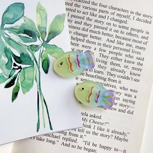 Macro detail of translucent resin fish hair clips with colorful gradient patterns