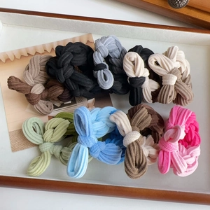 Close-up of colorful corduroy bow hair ties set neatly arranged in a wooden tray