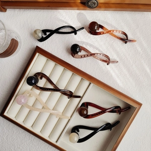 Detailed collection of banana hair clips with round beads in various neutral colors