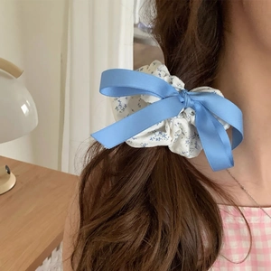 Detail of sea salt blue floral bow scrunchie showing fabric texture and satin ribbon