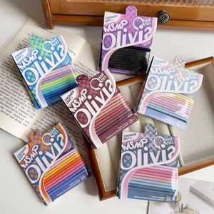 Macro shot of 10-pack elastic hair ties in various candy colors on a vintage book